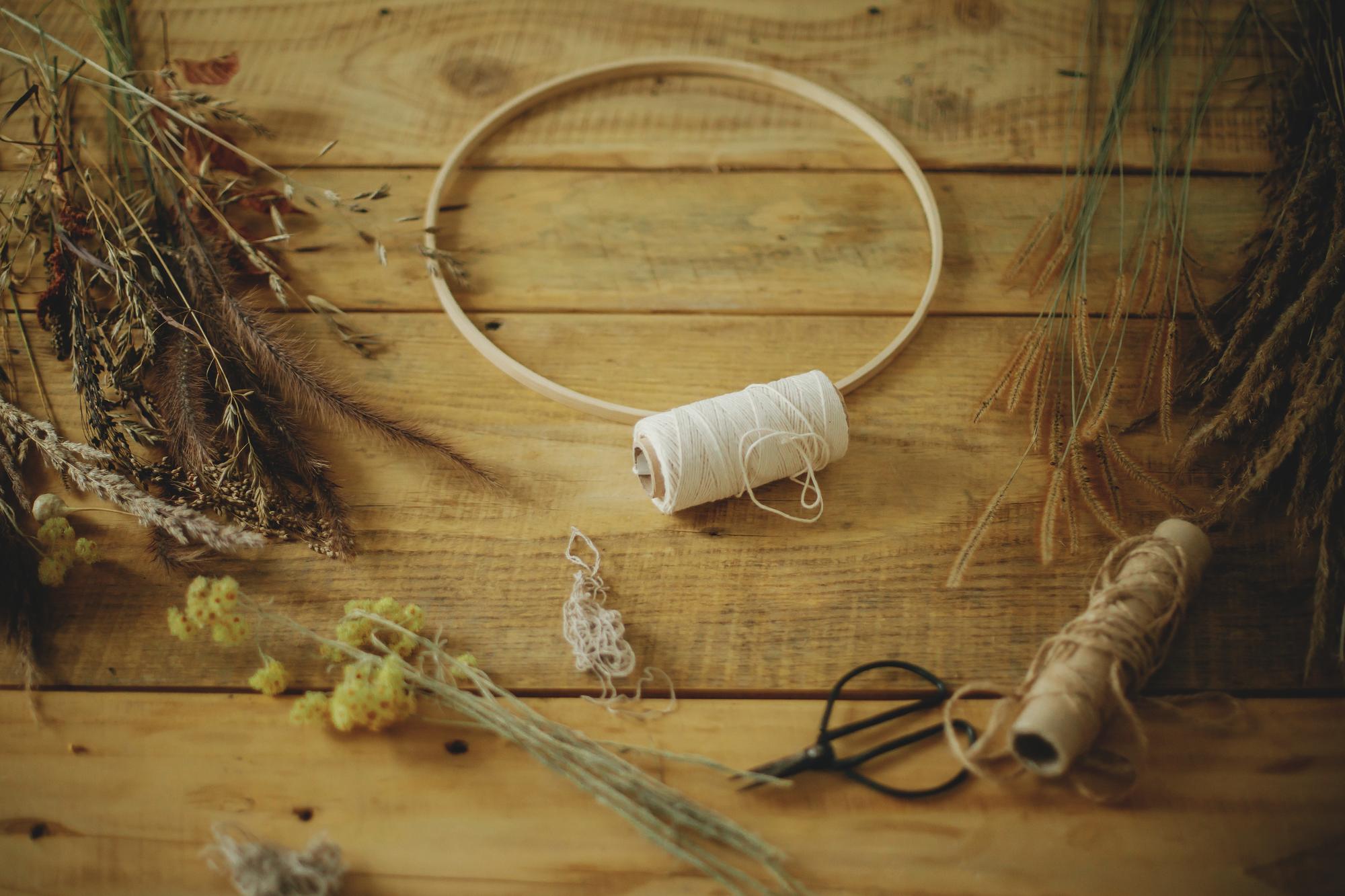 studio workspace with threads and hoop on wooden table