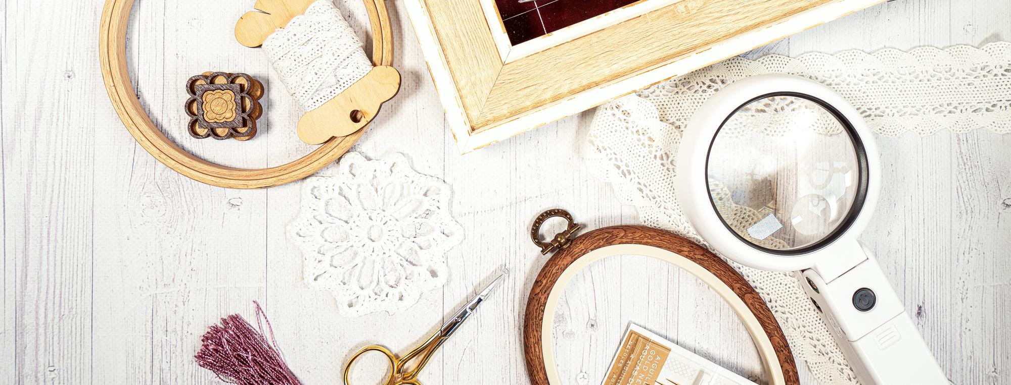 artisan sewing tools and embroidered sample on table